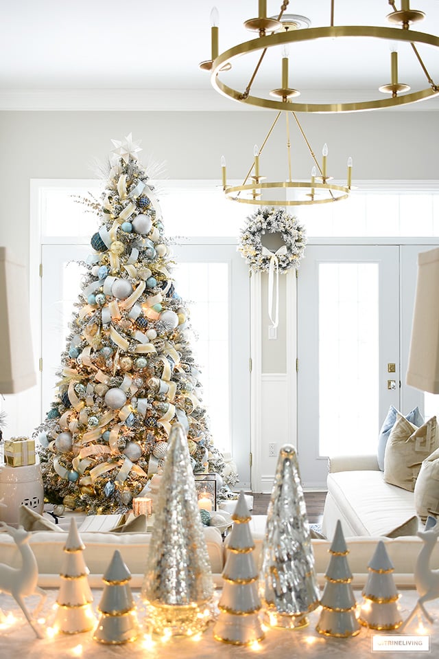 Living room with double french doors, flocked Christmas tree and wreath.