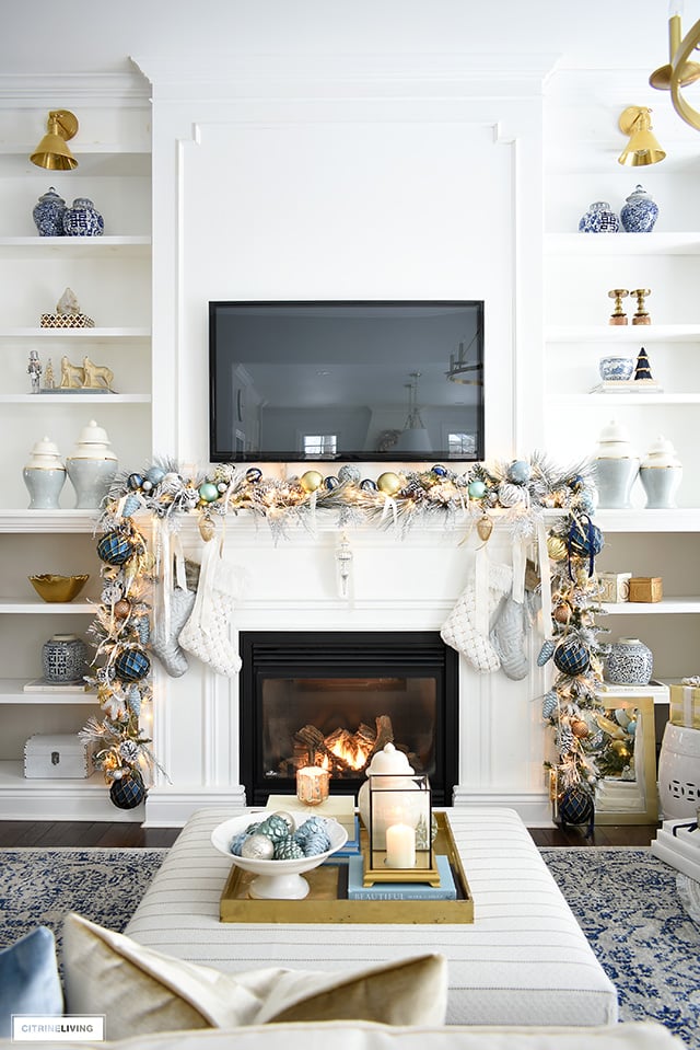 Elegant Christmas living room - Gorgeous Christmas mantel with flocked garland, light blue and gold decorations.