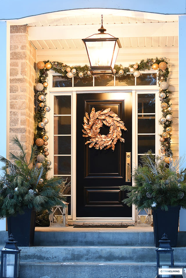 Front steps with oversized pendant light, god Christmas wreath and decorated garland.