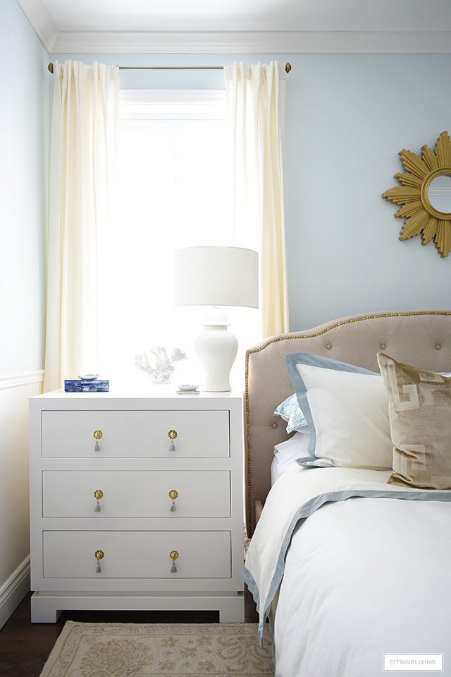 Chic and elegant three drawer nightstand with brass hardware and tassel pulls.