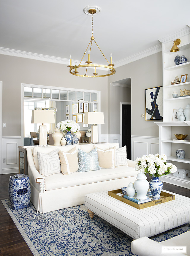 Elegant living room decoratating for spring with faux flowers, blue and white chinoiserie details and pale blue accents.
