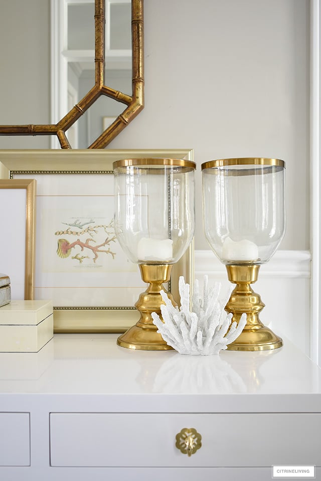 Style a console table with a coastal-chic look - use a coral sculpture and coral printed art for a layered, curated look.