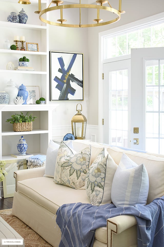 Summer decorating at it's best! Pretty blue ginger jars, baskets, greenery, floral and light blue pillows, a beautiful throw...gorgeous details create a breezy coastal look!