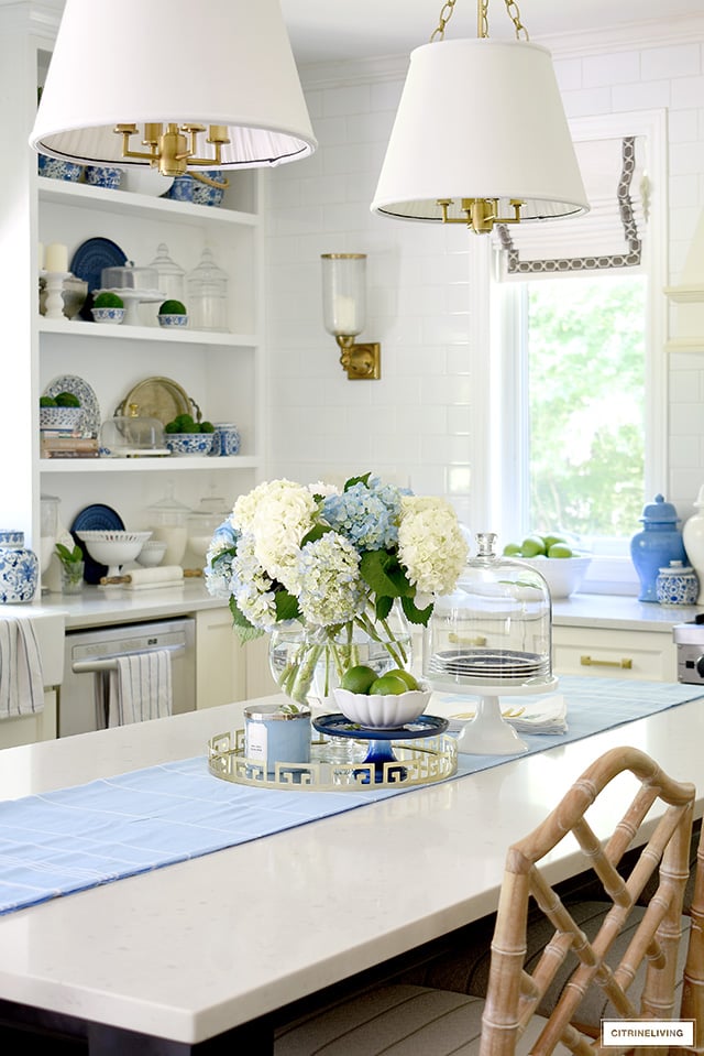 Beautiful kitchen styled with blue and white hydrangeas, fresh limes, green apples and blue and white accents.