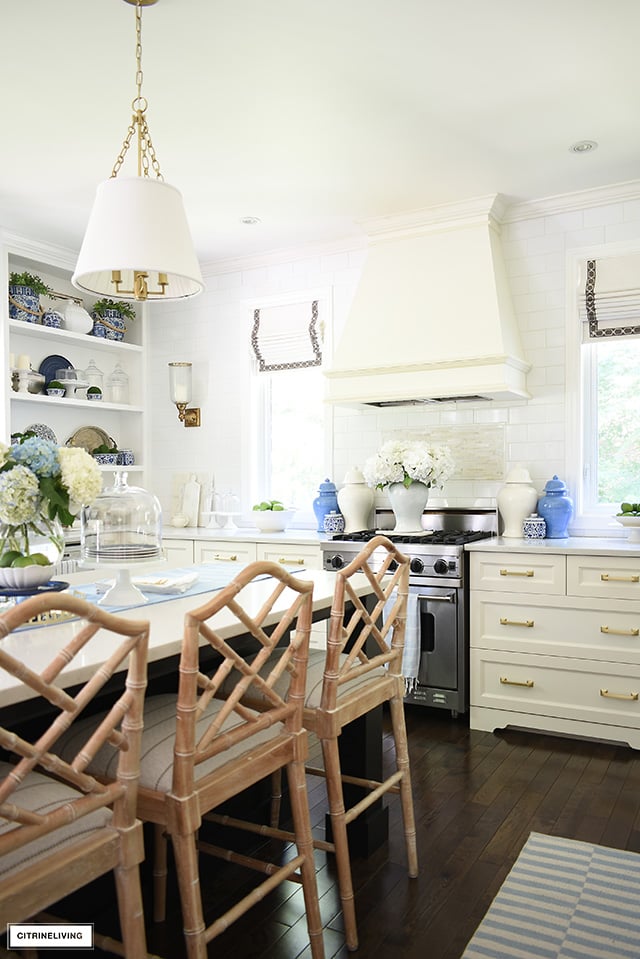 Summer kitchen decorated with blue and white ginger jars, flowers and striped rugs.