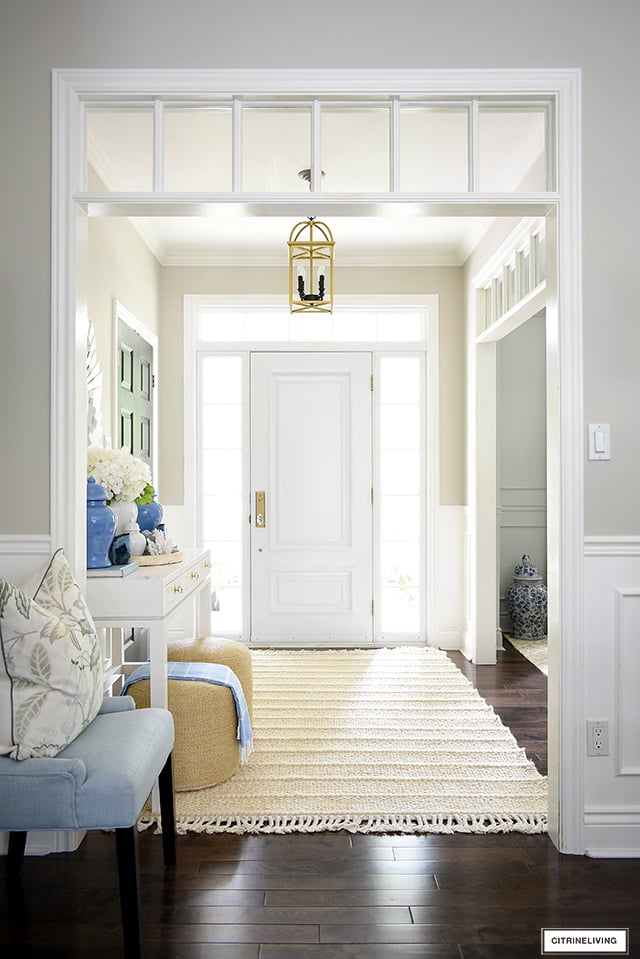 Entryway decorated for summer with a pretty blue, white and natural palette.