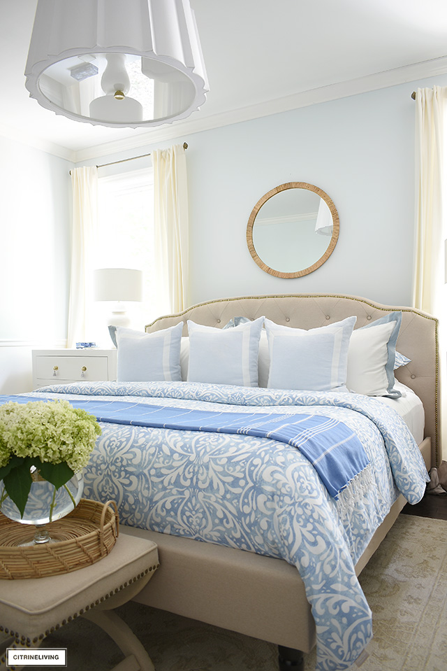 Beautiful summer bedroom featuring light blue and white bedding, throw pillow and throw for a gorgeous monochromatic look.