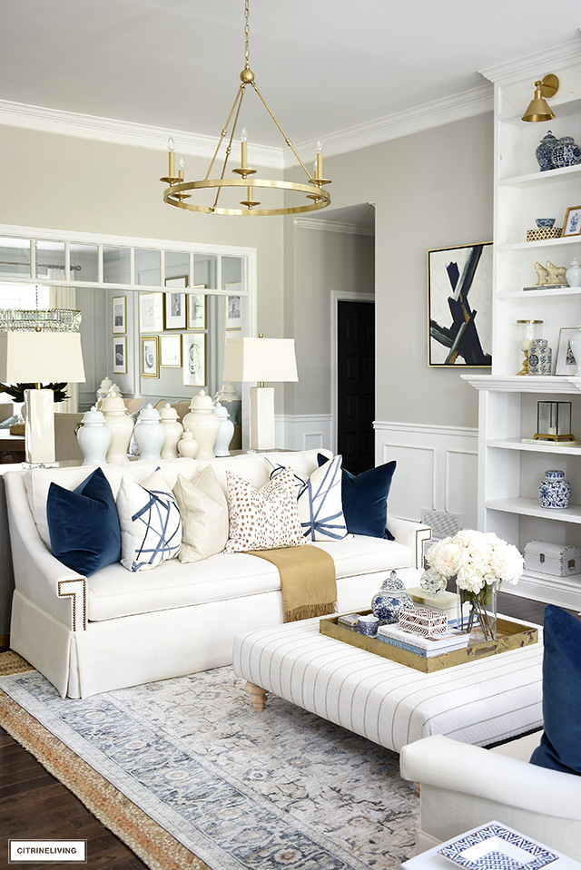 White living room sofa with luxe throw pillows in navy, brown, cream and a gold shimmer. Beautiful and luxe for the fall season.