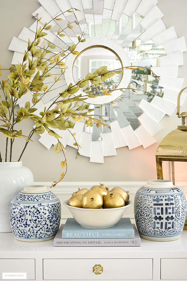 Gold painted fruit, faux branches, ginger jar and a gold lantern are perfect for a beautiful fall display.