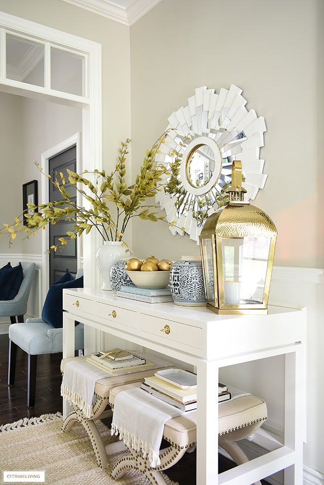 Foyer console table decorating for fall - gold, blue and white, faux branches and fruit are a gorgeous welcome for the season!