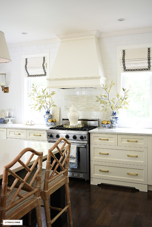 White kitchen decorated for fall with blue and white chinoiserie, faux branches and gold pomegranates is a chic take on the season.
