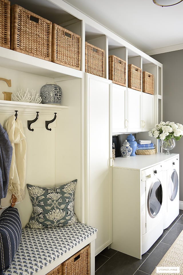 Laundry room with builtin cabinets and bench for storage and practical daily usage.