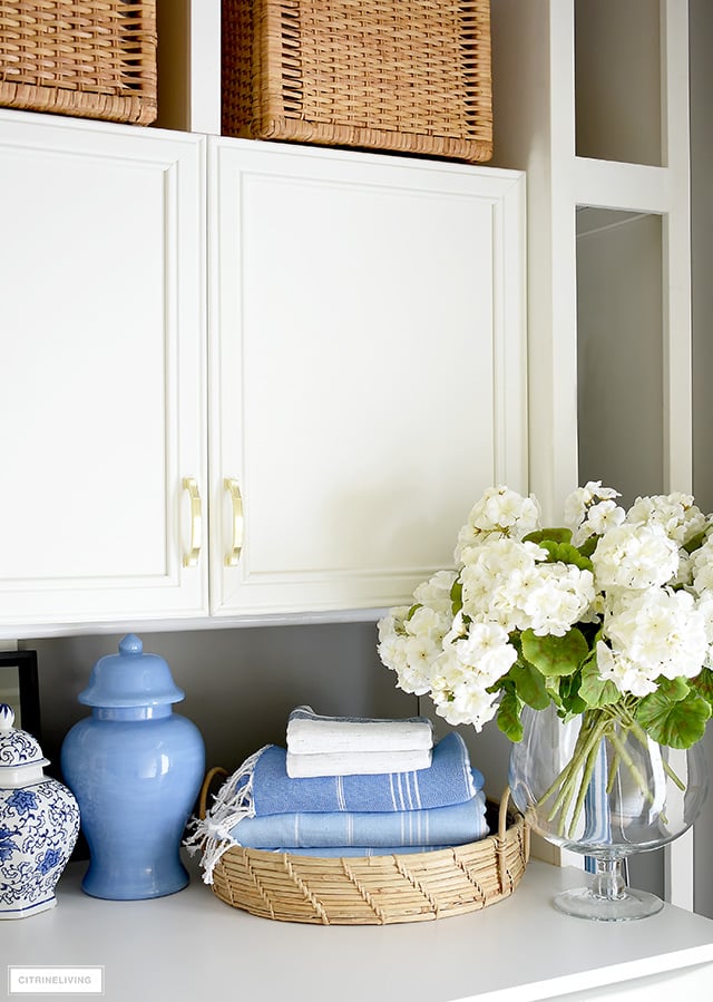 Laundry room decorated with geraniums, ginger jars and turkish towels.