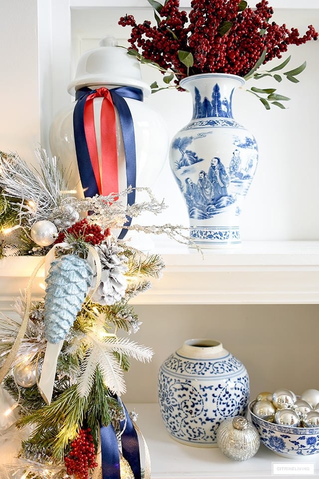 Christmas garland closeup - red berries, greenery and ribbons add special touches! Arrange blue and white vases and jars with simple ornaments for a beautiful display. 