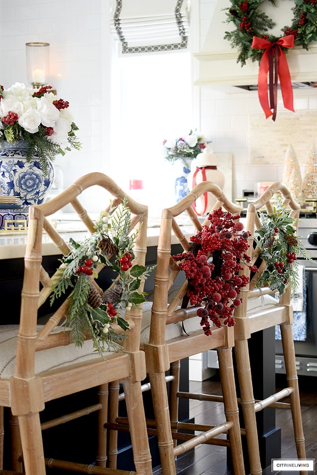 Christmas kitchen decor with festive wreaths tied onto barstools.