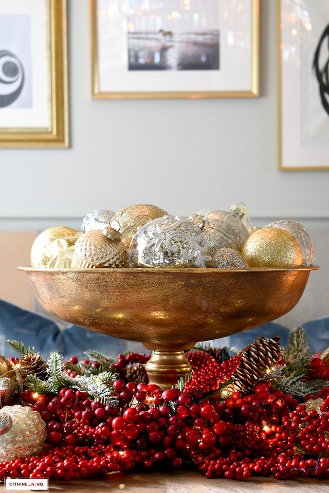 A footed bowl full of beautiful ornaments surrounded by layers of red berries makes a dramatic centrepiece!