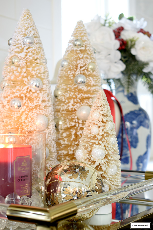 Pretty bottle brush trees syled on a tray with a scented candle and ornament.