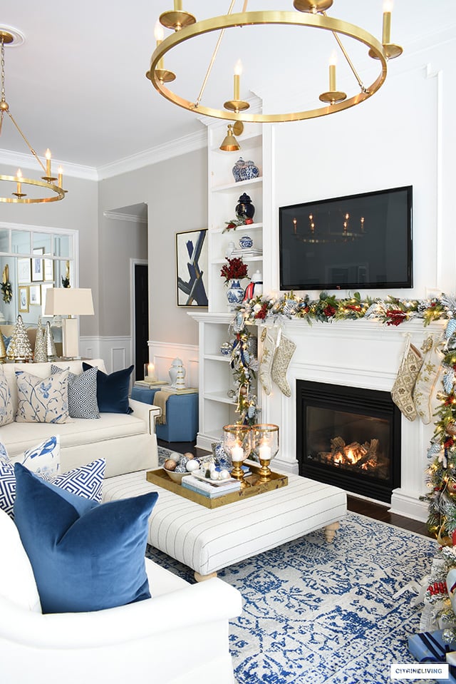 Living room decorated for Christmas with blue, white, red and gold.