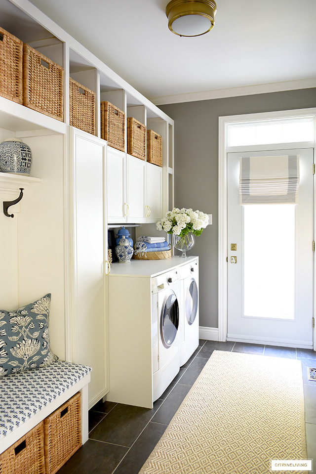 Laundry room organized with woven baskets and decorated with blue and white textiles.