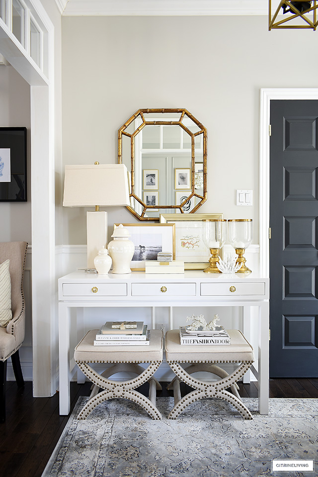 Console table styled with coastal elements like framed art and coral sculptures has a curated and collected look.