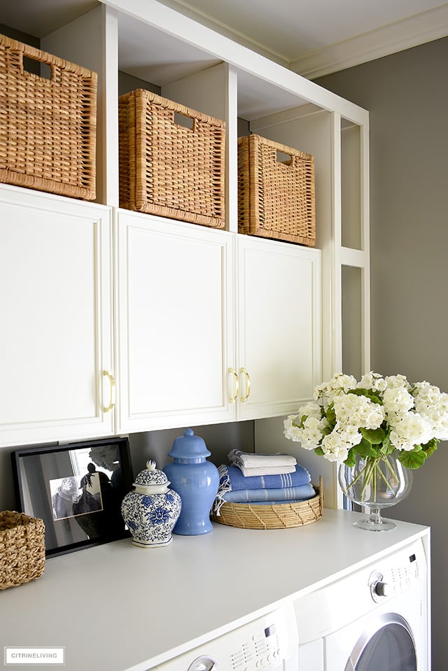 Laundry room decorated with faux geraniums, ginger jars and turkish towels.