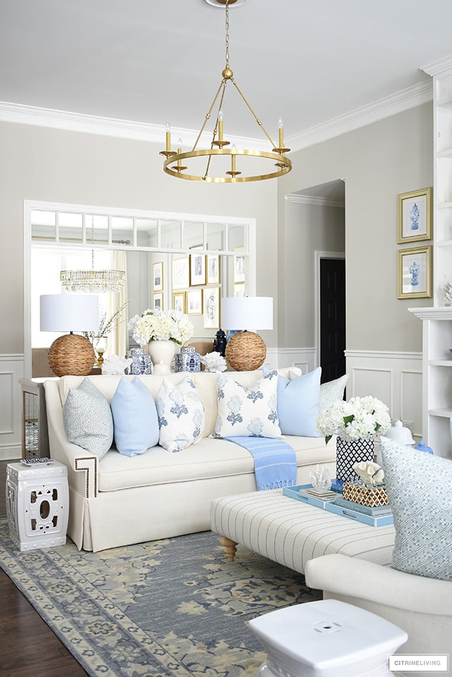 Spring living room decor - soft blue and floral pillows, soft blue tribal print rug, woven and natural touches and chinoiserie are casual, chic and livable.