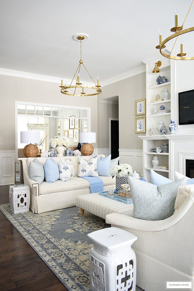 Living room decorating for spring - a beautiful color palette with soft blues and warm whites accented with coastal and natural touches, ginger jars and faux florals.