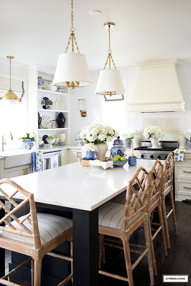 Kitchen styled for spring with blue and white accents, Chinese chippendale barstools and faux florals.