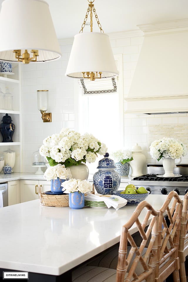 Beautiful kitchen styled for spring with faux florals, blue and white chinoiserie, and green accents.