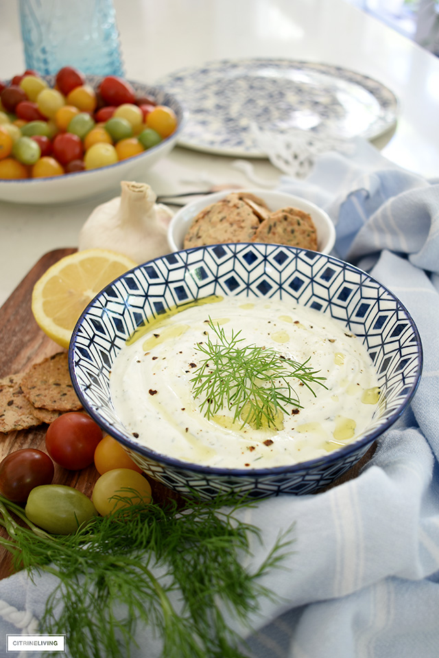 Greek yogurt dill dip served ob a platter with crackers and veggies