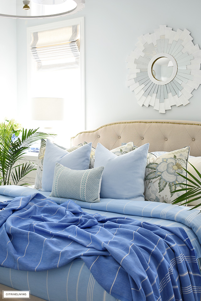 Designer throw pillows layered in soft blues and light greens is a fresh and airy look for summer.