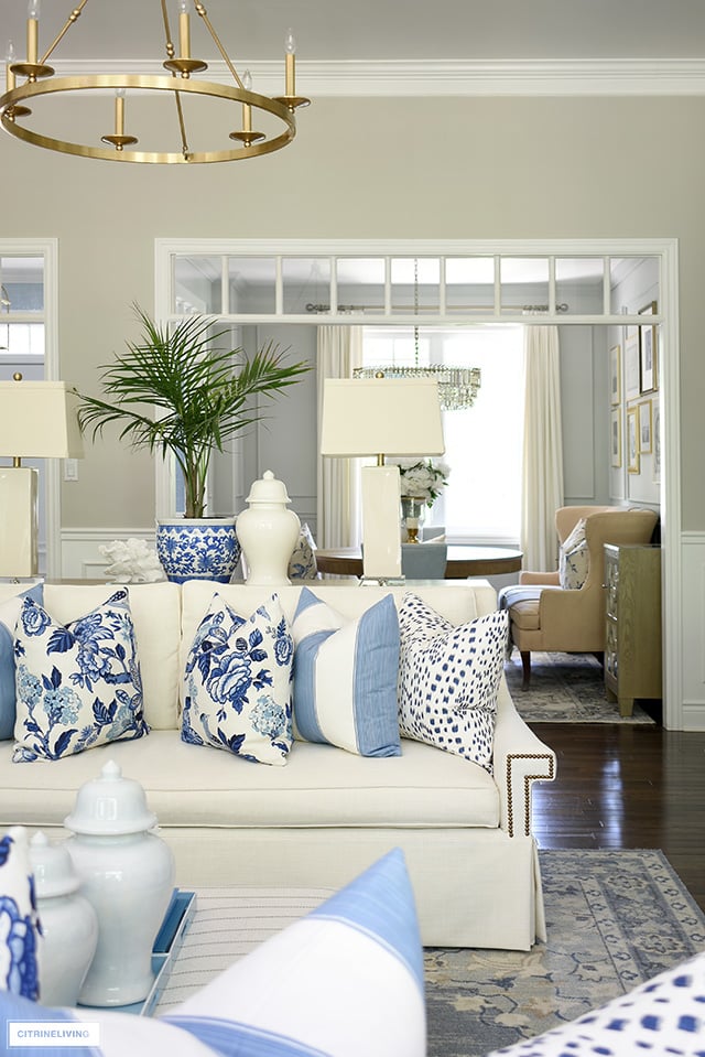 Living room sofa styled for summer with blue and white pillows.