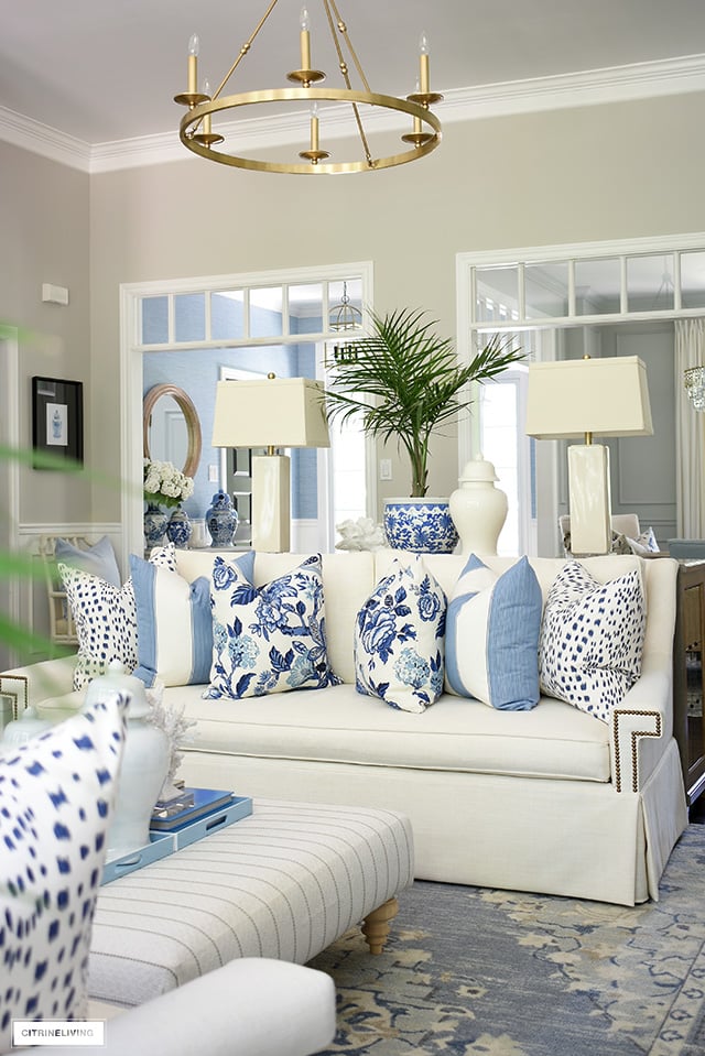 Summer living room decor with blue and white pillows, chinoiserie, coral, palms and ginger jars.