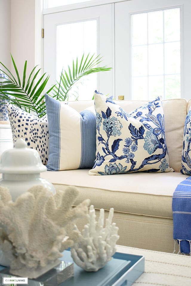 Hamptons syle pillows in blue and white styled on a tailored white sofa.