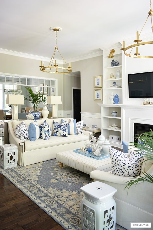 Living room decorated for summer with blue and white decor and palms is breezy and beautiful.