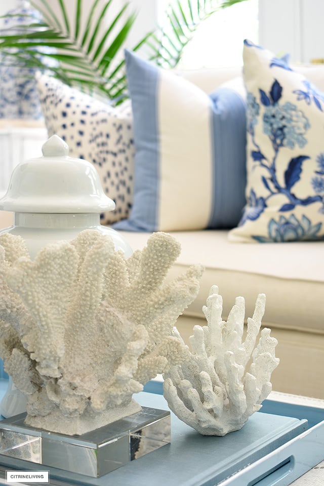 Coral sculptures styled for summer on a light blue tray.