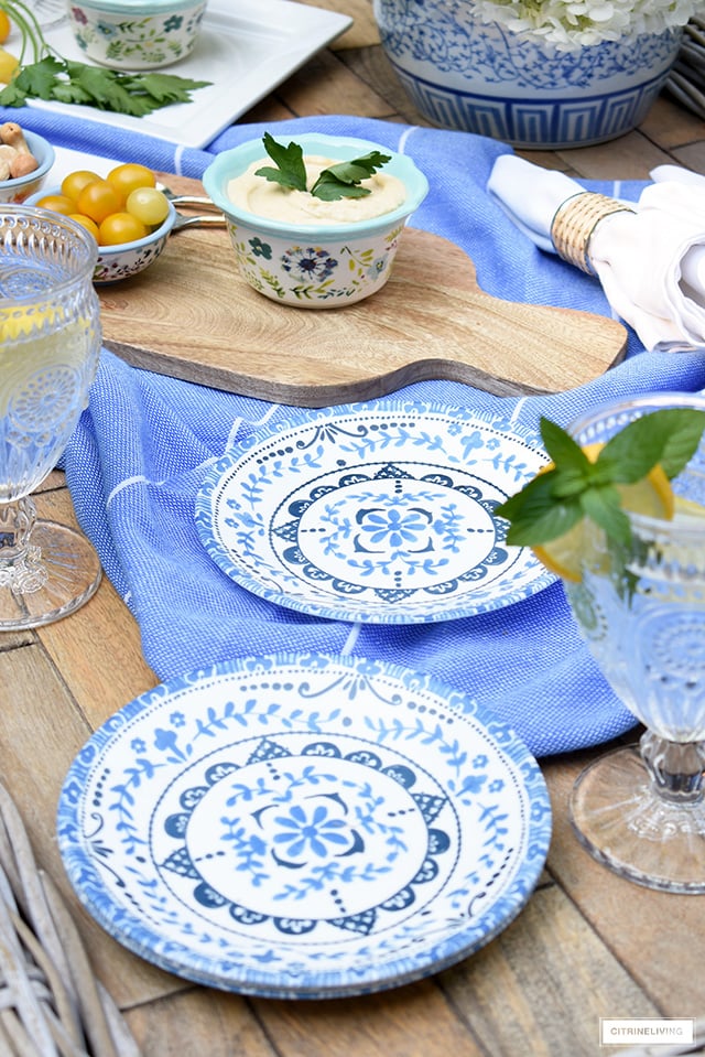 Outdoor table styled with blue and white dishes for casual and elegant dining. 