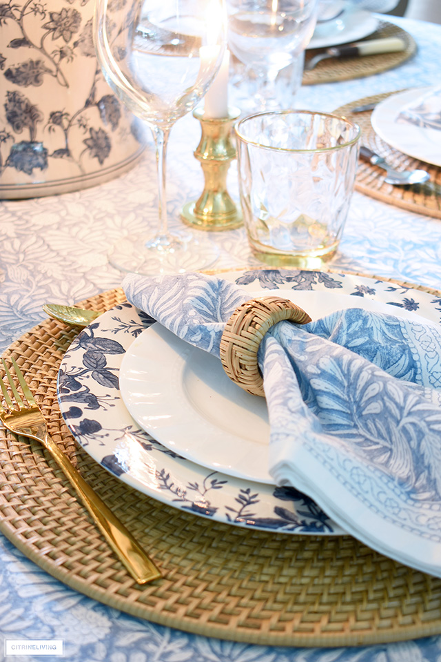 Fall table setting with woven placemats, blue and white floral dishes and block print blue linens.