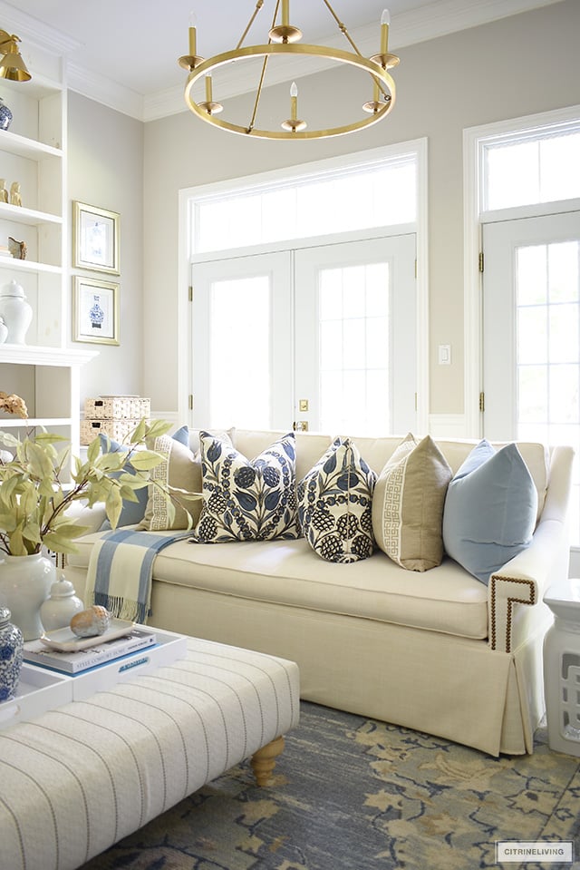 Living room decor with a blue and beige color palette - designer pillows, faux leaves and simple seasonal touches.