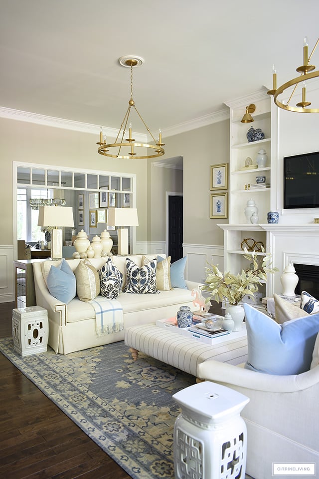 Living room decorated for fall with elegant designer throw pillows, cozy plaid throws and minimal seasonal touches.