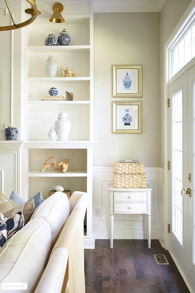 Living room styled with coastal elements - woven boxes, driftwood, and agate.