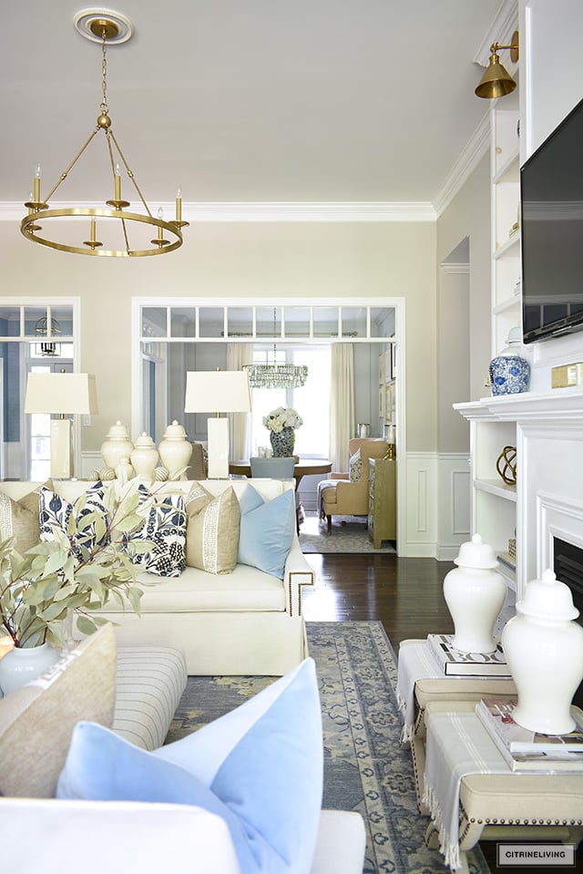 Living room styled for fall with elegant pillows in blues and warm neutrals, ginger jars and simple seasonal decor.