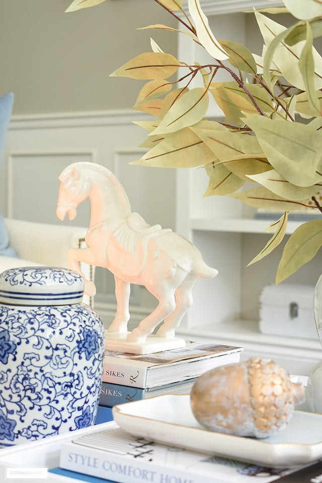 A beautiful horse sculpture styled on a tray with design books and fall accents.