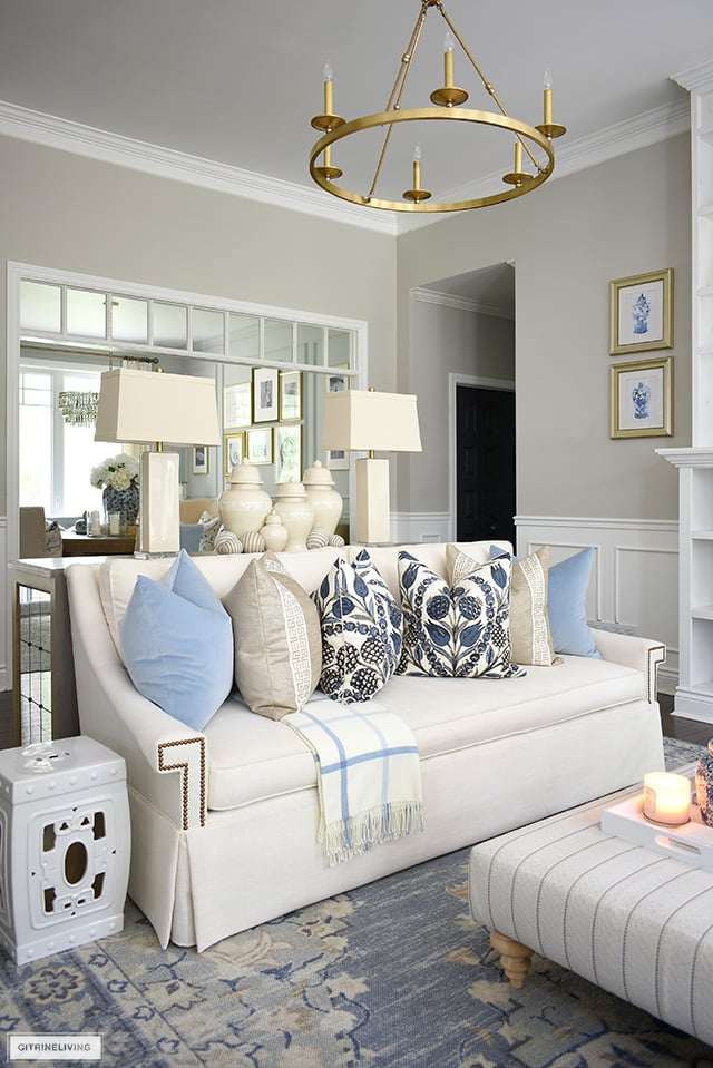 Fall living room decor, white sofa styled with designer pillows in blues and beiges.