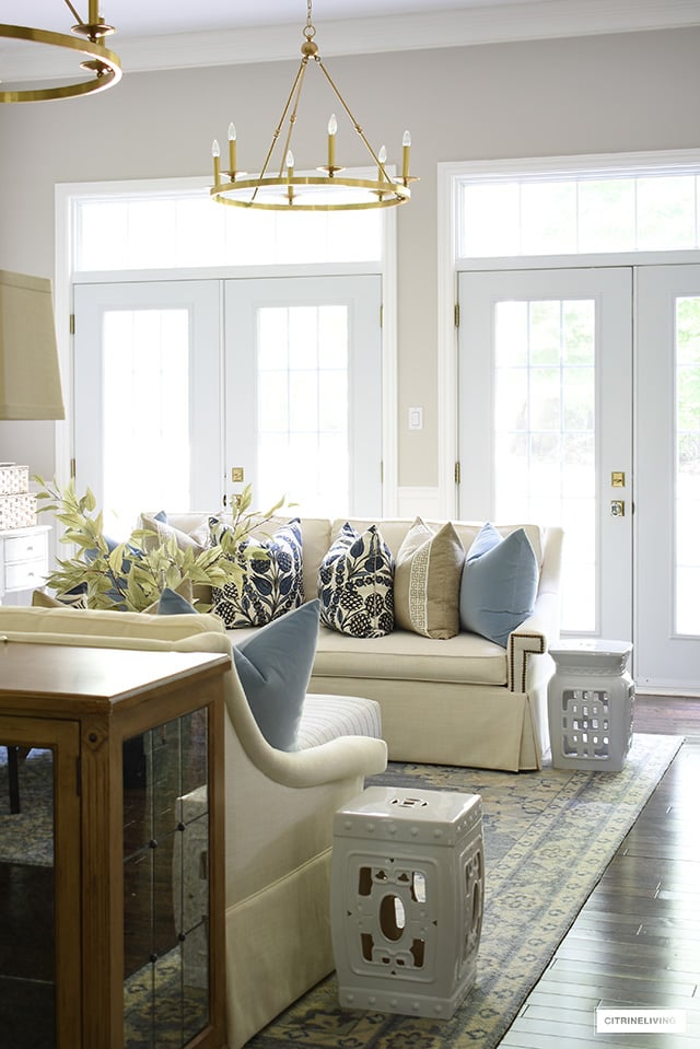 Living room decorated for fall with designer pillows, faux fall foliage and simple accessories.