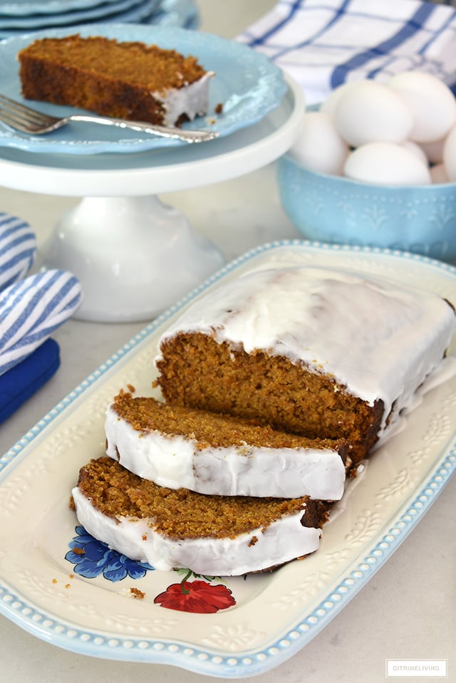 Slices of pumpkin loaf with glaze served on a pretty platter.