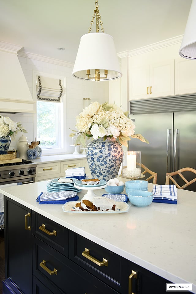 Kitchen island styled for fall with light blue dishes and kitchen towel set.