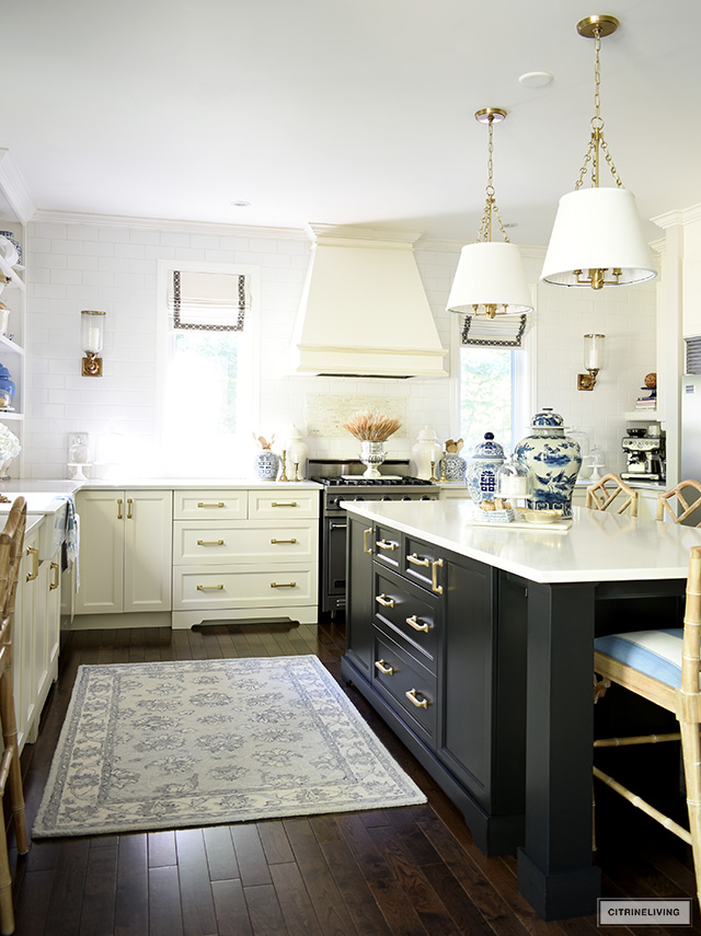 White kitchen with a black island and blue and white chinoiserie accents.