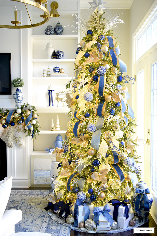 Gorgeous blue and gold Christmas tree, garland and bookshelves.