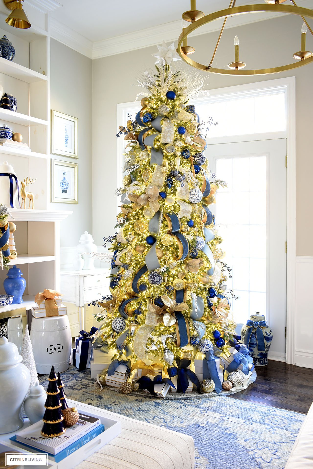 Elegant 9 foot slim Christmas tree decorated in gorgeous blue and gold decorations, ribbon and tree picks.